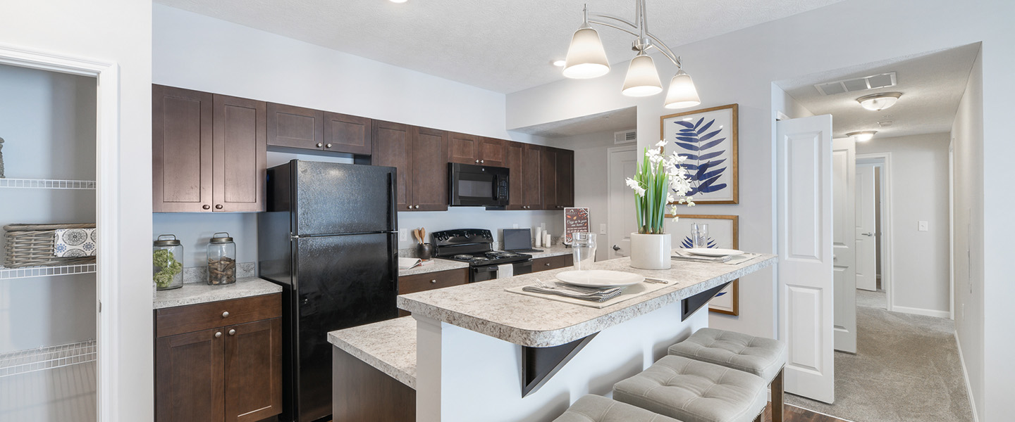 a kitchen with stainless steel appliances and a large island at The Adams Pointe